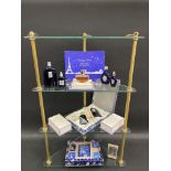A selection of new old stock perfumes and packaging on a brass framed three tier glass corner