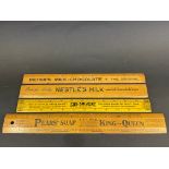 Three wooden rules and a metal rule, all with advertising for Peter's Milk Chocolate, Nestle's Pears