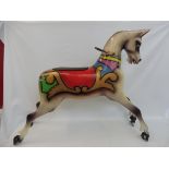 An original 1950s carousel horse, with later fairground painted scrollwork additions, horse with