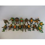 A tray of Teenage Mutant Ninja Turtles with weapons and accessories, various generations.