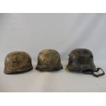 Three German style re-enactment helmets, one in the style of German Parachute Regiment,