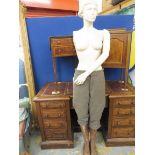 A one-armed female mannequin clothed from the waist down including tall brown leather lace up boots.