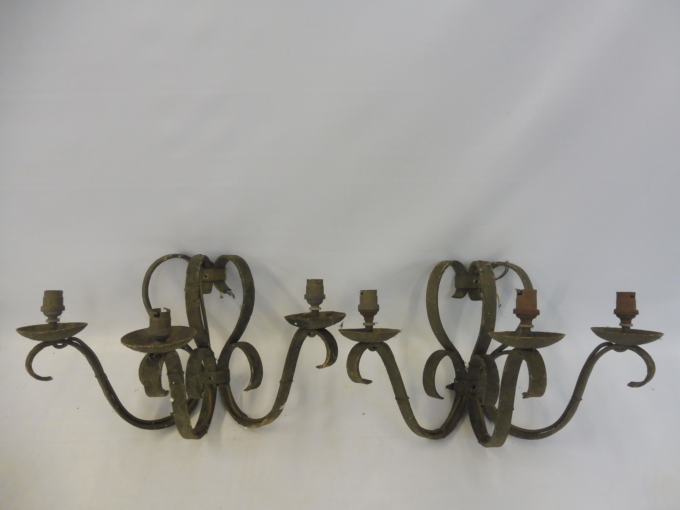 A pair of three branch wrought iron wall lights.