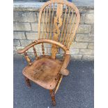 A 19th Century ash and elm windsor chair with a pierced splat to open scrolled arms, raised upon