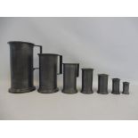 An unusual graduated set of seven pewter tankards, in the Arts and Crafts style, marked to the