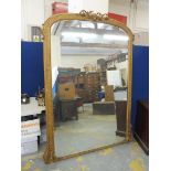 A very large late Victorian or early Edwardian gilt framed dome topped mirror, with scrolled