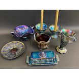 A selection of blue carnival glass including a butter dish, a pair of candle holders and a '