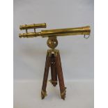 A brass table top telescope on a folding stand.