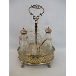A silver plated table top cruet holder with an array of glass bottles, three with silver tops.