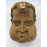 A large and unusual Folk Art stylised carved wooden mask, a male character with scrolled curly hair,