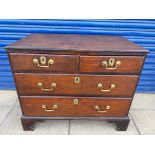 A Georgian oak chest of two short over two long drawers with brass swan neck handles and bracket