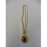 A yellow metal pendant set with lapiz lazuli.