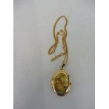 A 9ct gold pendant with an image of a lady and gentleman set by a tree.