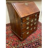 An 18th Century mahogany bureau on squat bun feet, lacking glazed upper section, with good fitted