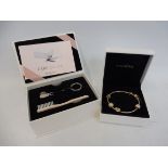 A Pandora gold bracelet with four charms in original boxed with cased Pandora care kit.