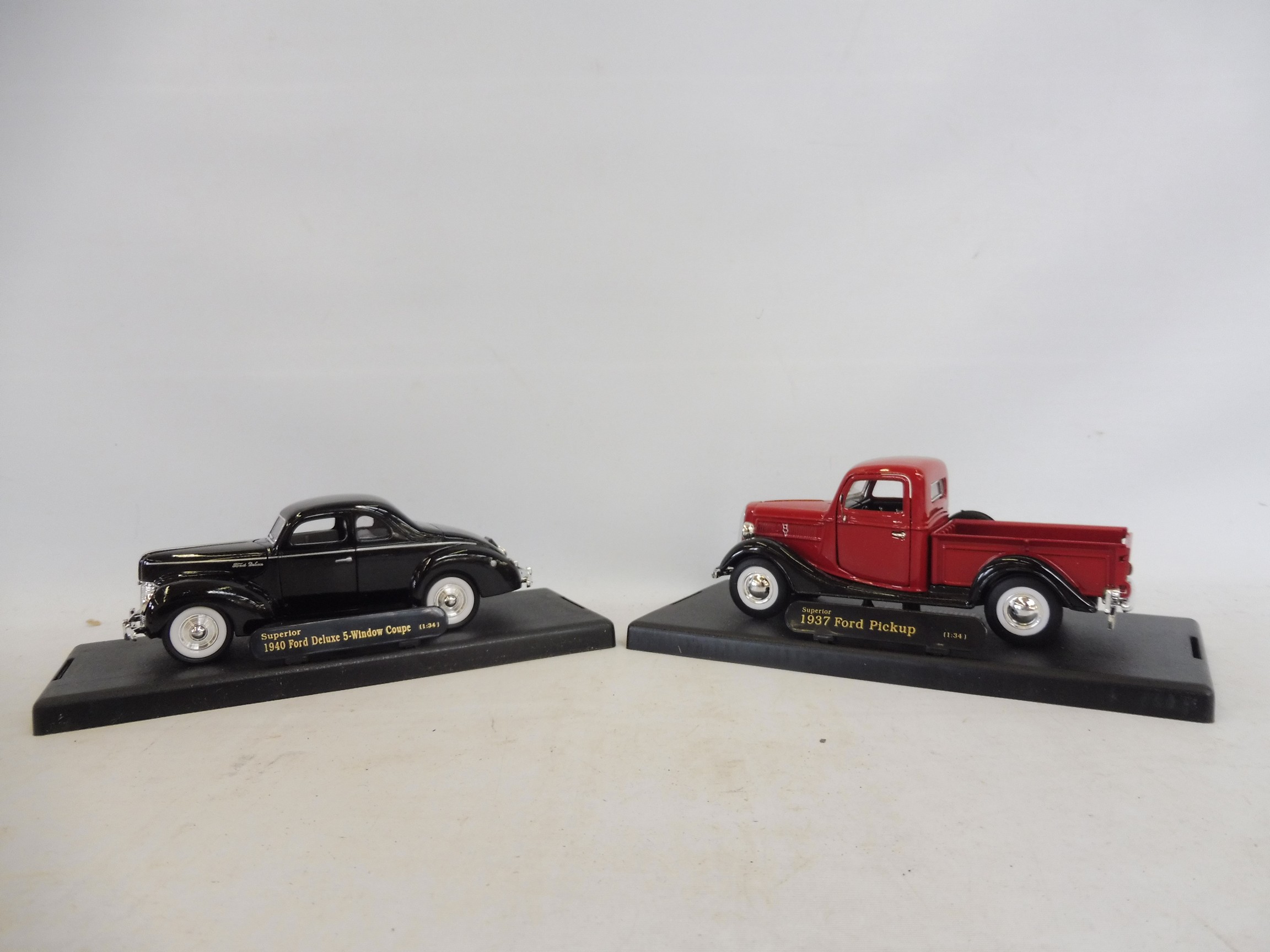 Two boxed die-cast models: a 1937 Ford pickup and a 1940 Ford Deluxe Coupe.