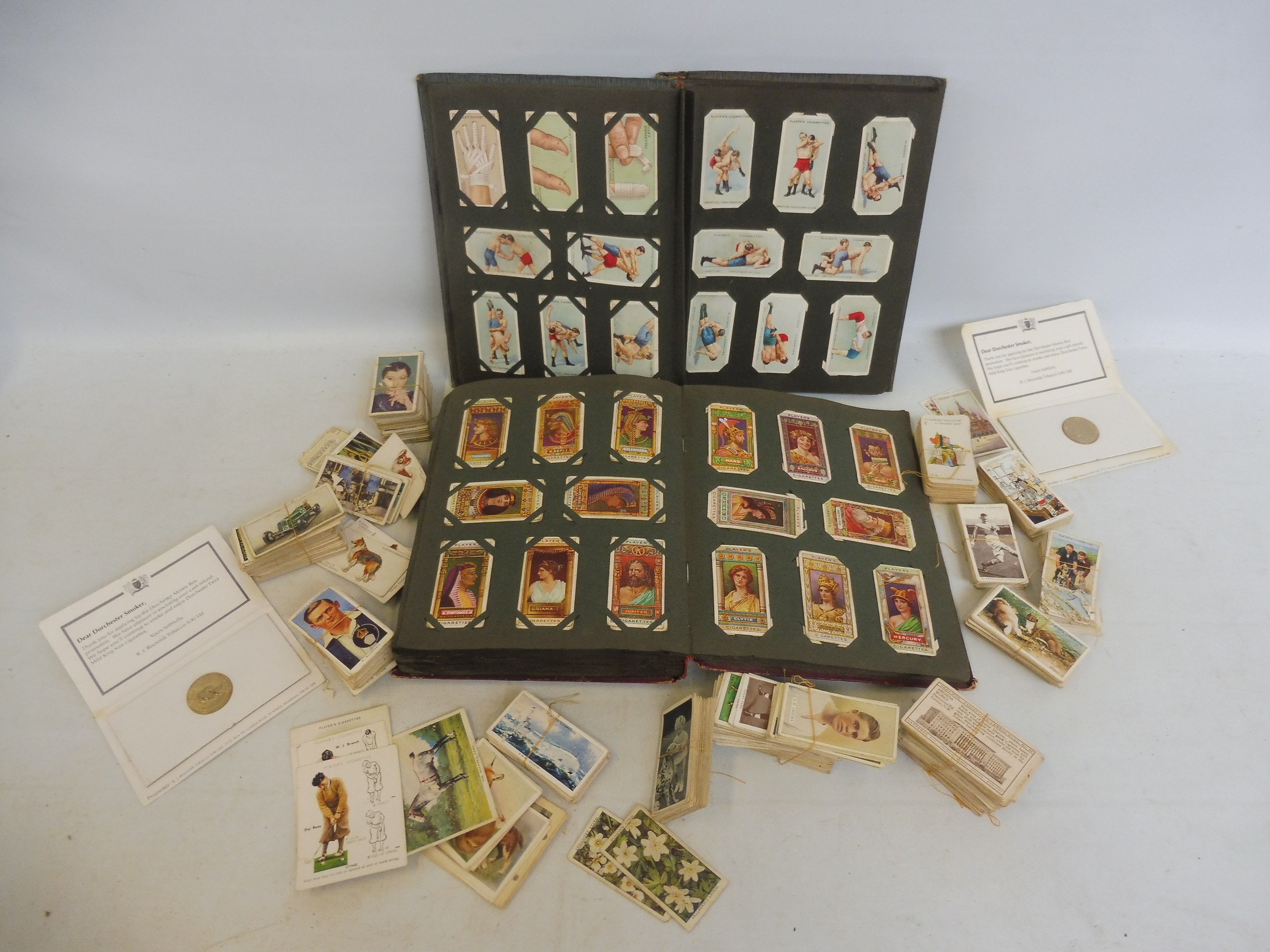 Two cigarette card albums and various loose cards.