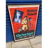 A framed and glazed original cinema poster for the film 'On The Beat' starring Norman Wisdom,