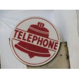 A circa 1950s American circular telephone illuminated lightbox with central image of a bell, on