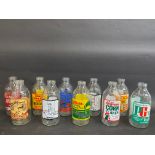 Sixteen glass milk bottles, all with advertising on.