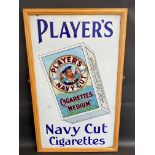 A Player's Navy Cut Cigarettes pictorial packet enamel sign in a frame, mounted on a board, two