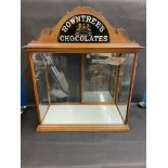 A large counter top dispensing cabinet with rear opening sliding doors and two glass shelves,