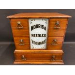 A Morris & Yeomans' Needles counter top dispensing chest of five drawers surrounding a glass