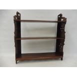 A mahogany wall mounted three tier open shelf with pierced fretwork ends, 19 1/2" w x 21" h x 5" d.