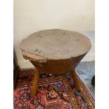 A gigantic 19th Century primitive elm chopping block, raised on three legs, diameter of top