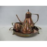An Arts and Crafts WMF copper and brass mounted three piece tea set on a circular stand, stamped