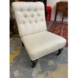 A late Victorian button back upholstered nursing chair raised upon ebonised supports to castors.