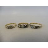 An 18ct gold three stone diamond ring, size L/M, plus two further 18ct gold three stone diamond