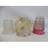 An Edwardian cranberry coloured glass lamp shade and two others.