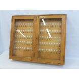 A light oak wall mounted key cabinet, filled with hooks for keys and adjacent numbers, 35 1/2" w x