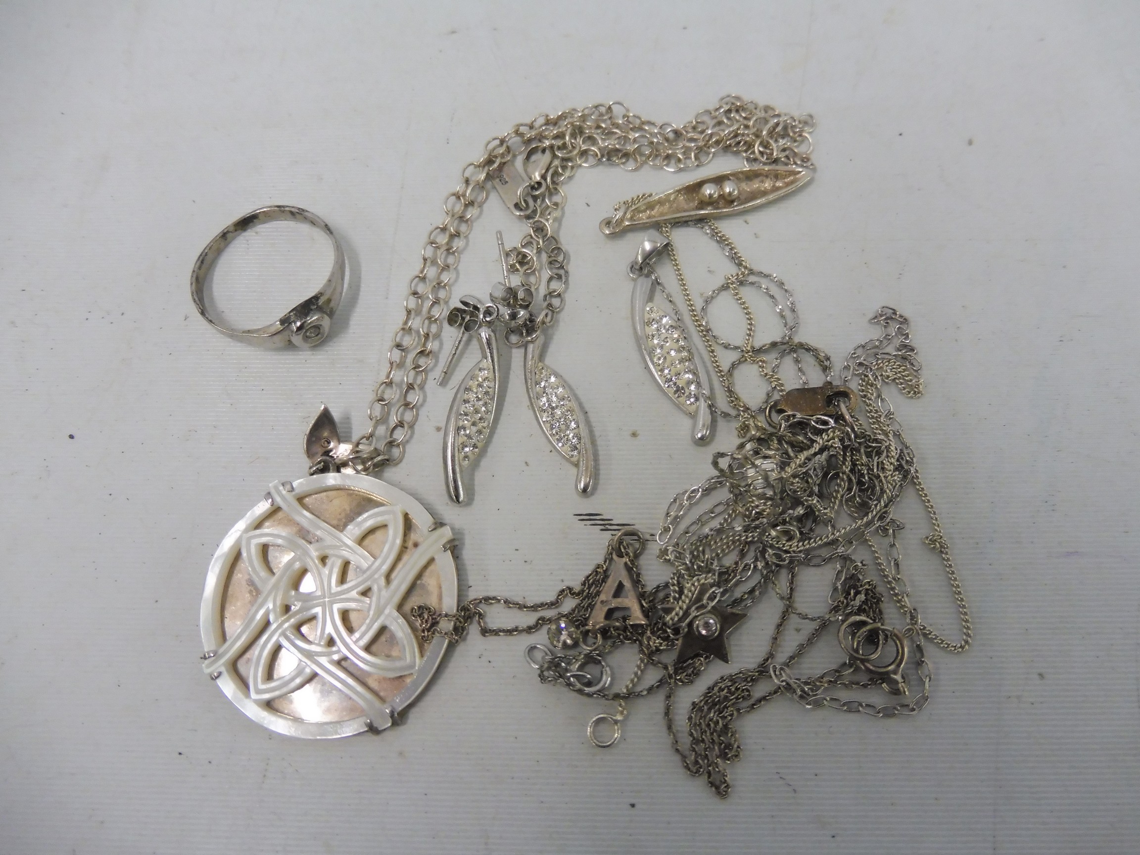 A silver ring, several silver chains, a contemporary pendant etc.