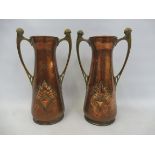 A tall pair of Arts and Crafts WMF embossed and hammered copper vases with shaped brass handles,