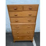 A Heals light oak chest of two short over five long drawers, one drawer with an inset celluloid disc