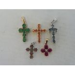 A 9ct gold cross set with green stones, possibly emeralds, and four others, two being white gold,