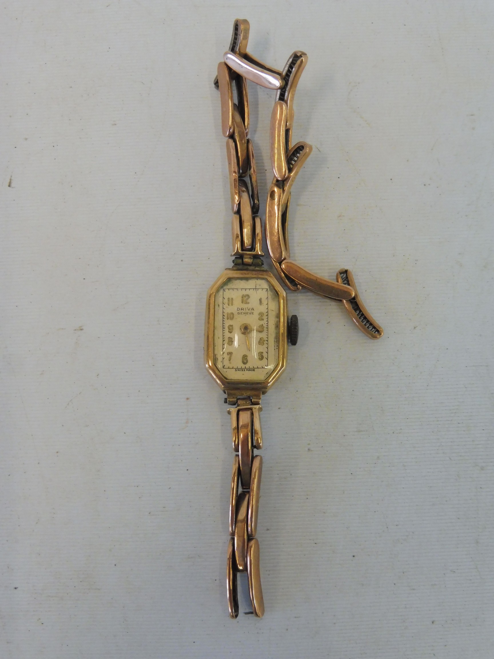 A 9ct gold ladies wristwatch with a broken 9ct gold expanding strap, 11.4g.