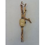 A 9ct gold ladies wristwatch with a broken 9ct gold expanding strap, 11.4g.