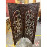 A two fold late 19th/early 20th Century hardwood screen with all over floral decoration, each fold