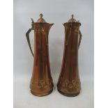 A tall pair of Arts and Crafts WMF copper and brass mounted jugs with two friezes of embossed
