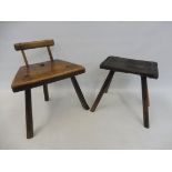 An early 19th Century primitive elm and ash stool with raised back, together with a primitive iron