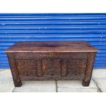 An 18th Century oak panelled coffer with plank top and carved front, 46 1/2" w x 22 1/2" h x 18" d.