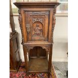An unusual early 20th Century oak single door cupboard, with well-detailed carved decoration in