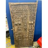 A tribal art carved wooden door, with well detailed relief decoration including a figure on