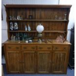 A vintage pine Dresser, the two-tier plate rack set on a base with four drawers and four panelled