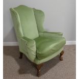An early 20thC Wing Armchair, in green upholstery, with carved cabriole front supports, 30½in (
