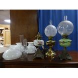 A late Victorian Oil Lamp, with pierced cast metal base and painted green glass reservoir, 21½in (