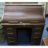 An early 20thC oak Roll Top Desk, by Warings (Waring & Gillow Ltd), the tambour front with fitted